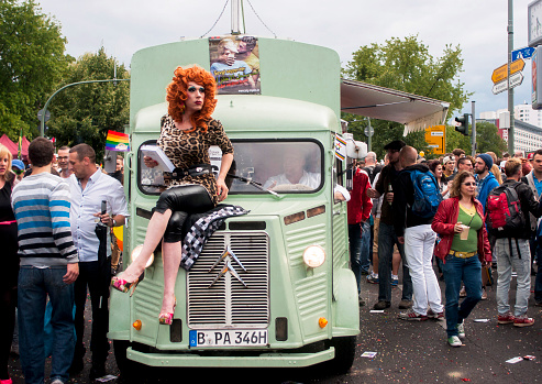 Berlin, Germany - June 21, 2014: Christopher Street Day.Crowd of people Participate in the parade celebrates gays, lesbians, bisexuals and transgenders.Prominent in the image a elaborately dressed transgender sitting on car.