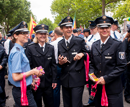 Berlin, Germany - June 21, 2014: Christopher Street Day.Crowd of people Participate in the parade celebrates gays, lesbians, bisexuals and transgenders.Prominent in the image a German Policewoman's in uniform.