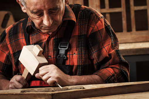 Senior carpenter restoring old furniture