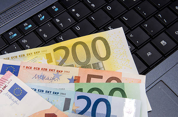 istock Money euro banknotes over laptop keyboard 500671008