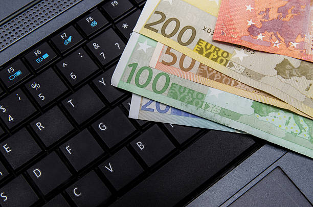 istock Money euro banknotes over laptop keyboard 500671216