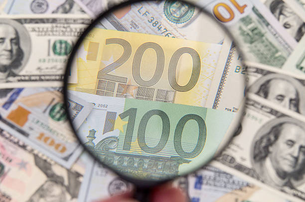 istock Magnifying glass over euro notes. US dollar in the background 500671844