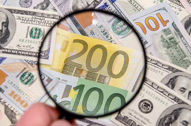 istock Magnifying glass over euro notes. US dollar in the background 500671950
