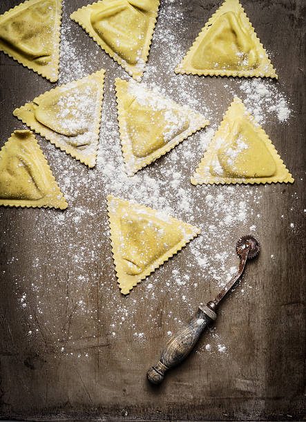 istock ravioli  Triangoli making, preparation on rustic wooden background 500673976