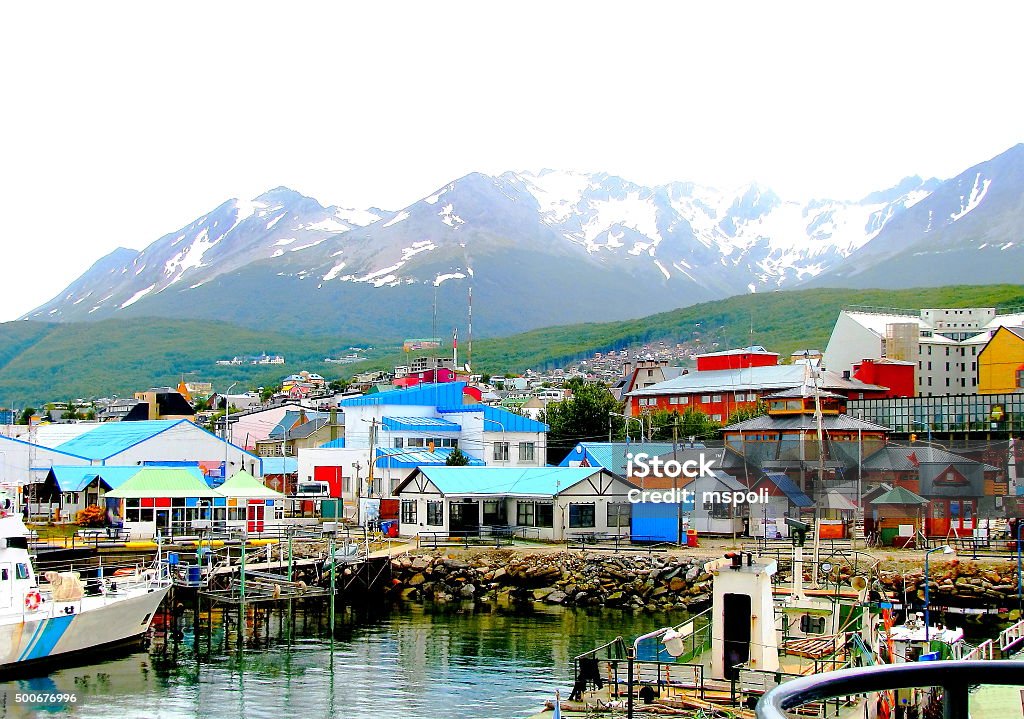 Colorful houses at the end of the world Multi colored houses in the Patagonian city of Ushuaia, Argentina. Ushuaia is the capital of the Argentine province of Tierra del Fuego. It is commonly regarded as the southernmost city in the world. Ushuaia is located in a wide bay on the southern coast of the island of Tierra del Fuego, bounded on the north by the Martial mountain range and on the south by the Beagle Channel. It is also the setting off port for many Antarctic cruises.       Ushuaia Stock Photo