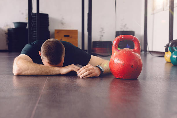 sportivo sdraiato sul pavimento della palestra - body building male muscular build posing foto e immagini stock