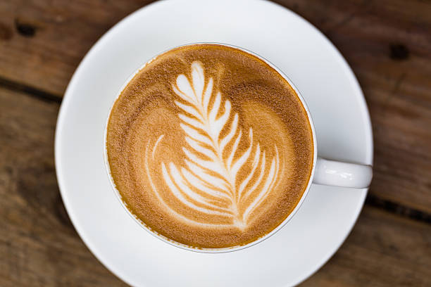 istock Cup of hot latte art coffee on wooden table 500682407