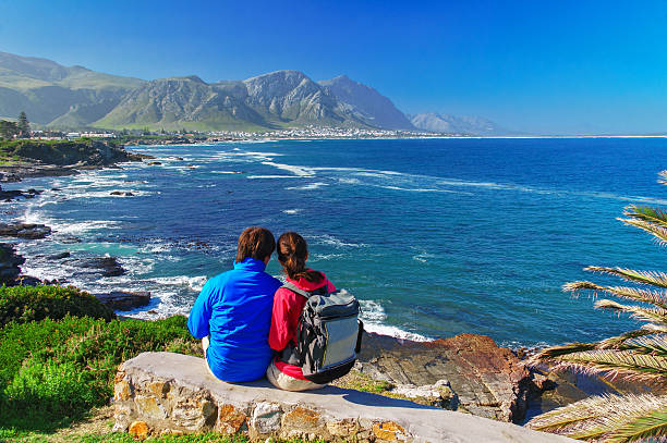 Happy couple looking at beautiful ocean view Happy couple looking at beautiful ocean view in Hermanus, romantic vacation in South Africa hermanus stock pictures, royalty-free photos & images