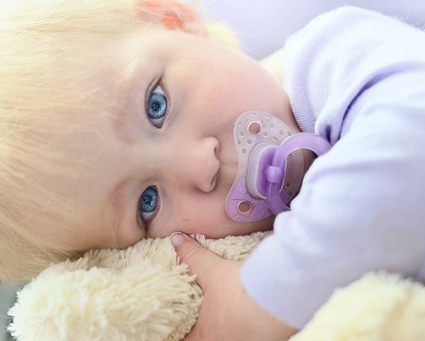 istock Cute baby with blue eyes hugging a mascot. 500689307