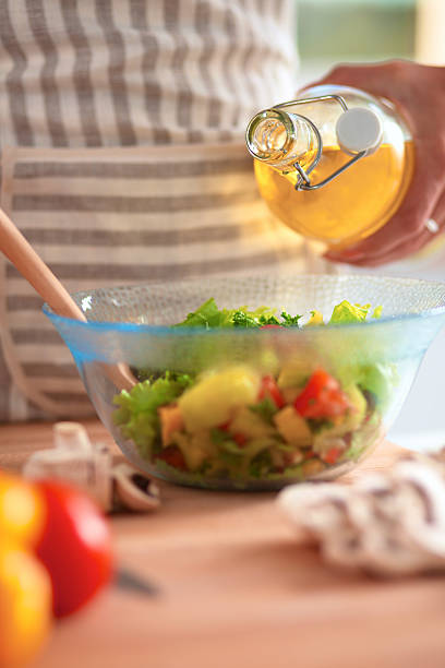 istock Smiling young woman  mixing fresh salad 500696874