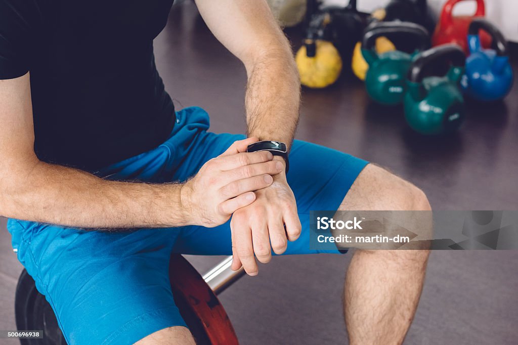 Sportsman using smart watch Man in the gym using smart watch 2015 Stock Photo