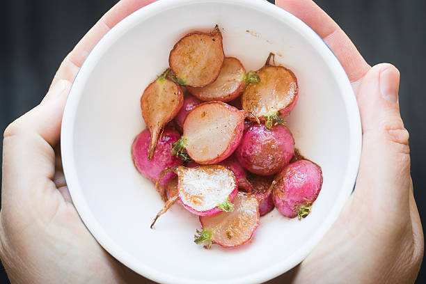 istock Hand holding small bowl with roasted radishes 500697116