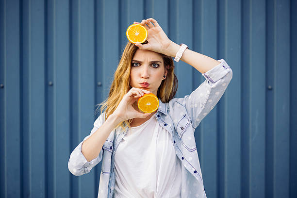 istock Smiling woman holding two orange in hands 500700414