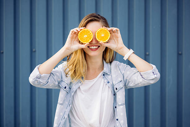 istock Smiling woman holding two orange in hands 500700442