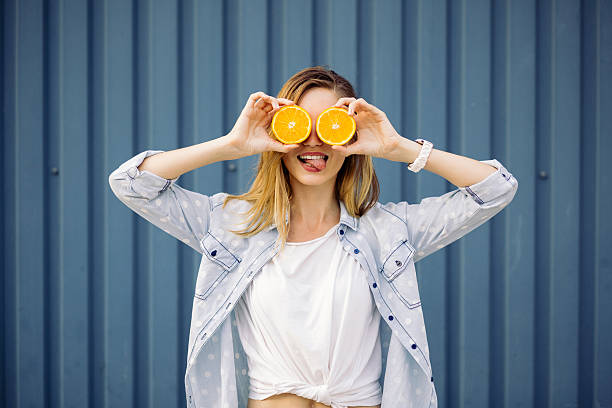 istock Smiling woman holding two orange in hands 500700640