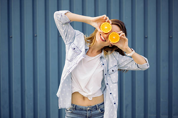 istock Smiling woman holding two orange in hands 500700726