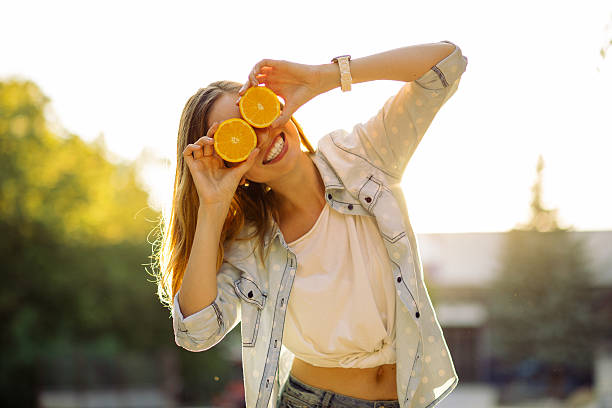 Smiling woman holding two orange in hands stock photo
