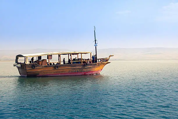 Sea of Galilee, Israel, Boat in sunset, Golan Heights in the background