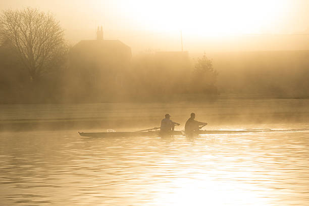 A photo of two rowing athletes rowing in the morning mist on the river thames in Henley-On-Thames