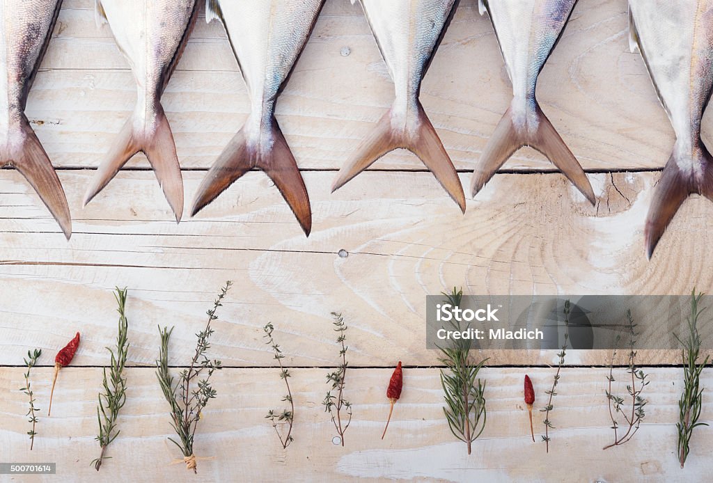 Raw fish, Yellowtail, in a row Fresh raw fish, Yellowtail, in a row on wooden background Mackerel Stock Photo