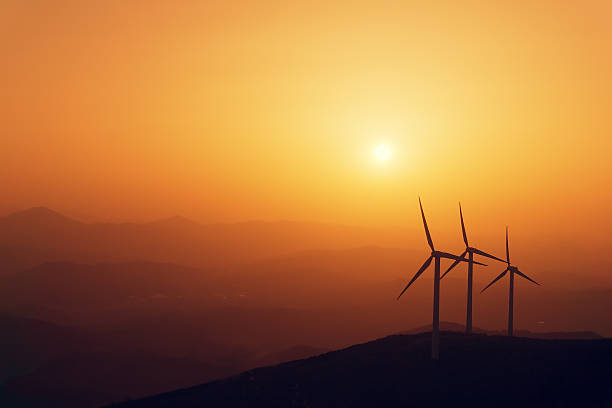 istock wind turbines silhouette on mountain at sunset 500701750