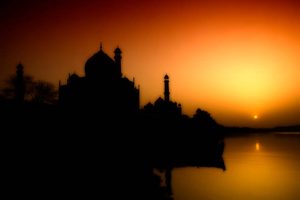 Silhouette of Taj Mahal during sunset from the bank of River Yamuna, Agra, India.