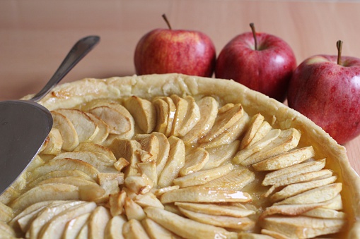 big piece of apple tart with red apples