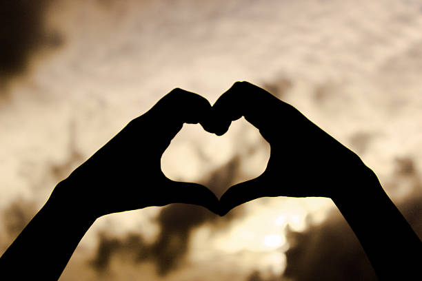 istock love shape hand silhouette in sky 500703766