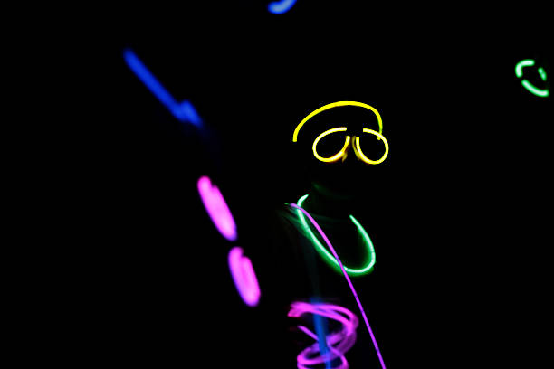 istock Person wearing colorful neon glow sticks at night 500704248