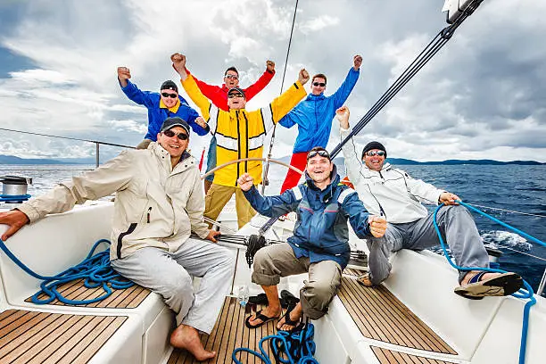 Happy sailing crew of 7 people having fun on sailboat. http://santoriniphoto.com/Template-Sailing.jpg