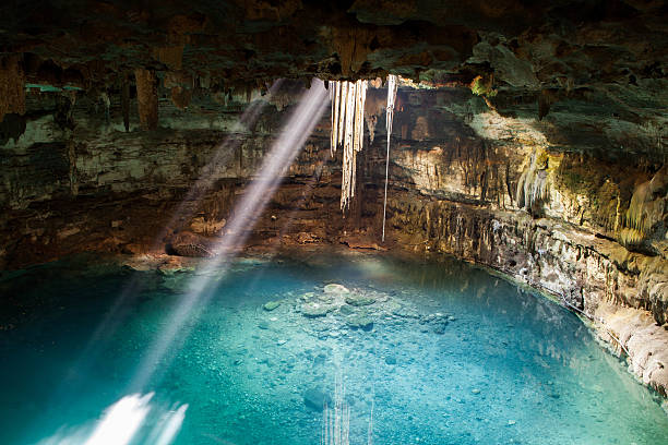Samula Cenote Sambula cenote is a beautiful underground cavern that will surprise you with its natural beauty and the breadth of the place. Its crystal clear turquoise blue are illuminated through a hole in the top of the cave where you can admire as the hanging roots of a tree has been cut into the surface but that is still alive because it follows the water feeding, admired the fish that live in and see clearly where their bottoms and deep here you can safely enjoy this cool and underground cenote. cenote stock pictures, royalty-free photos & images