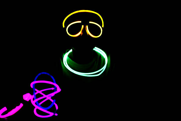 Person wearing colorful neon glow sticks at night
