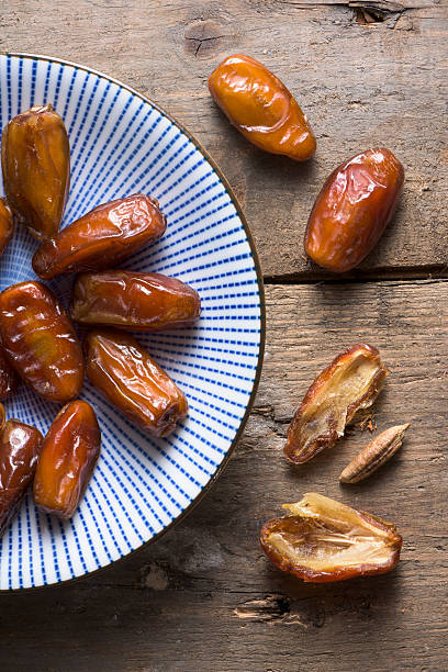 istock An overhead bowl of dates on a rough wooden background 500706802