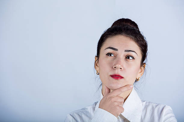 istock Young thinking woman looking up sideways 500707410