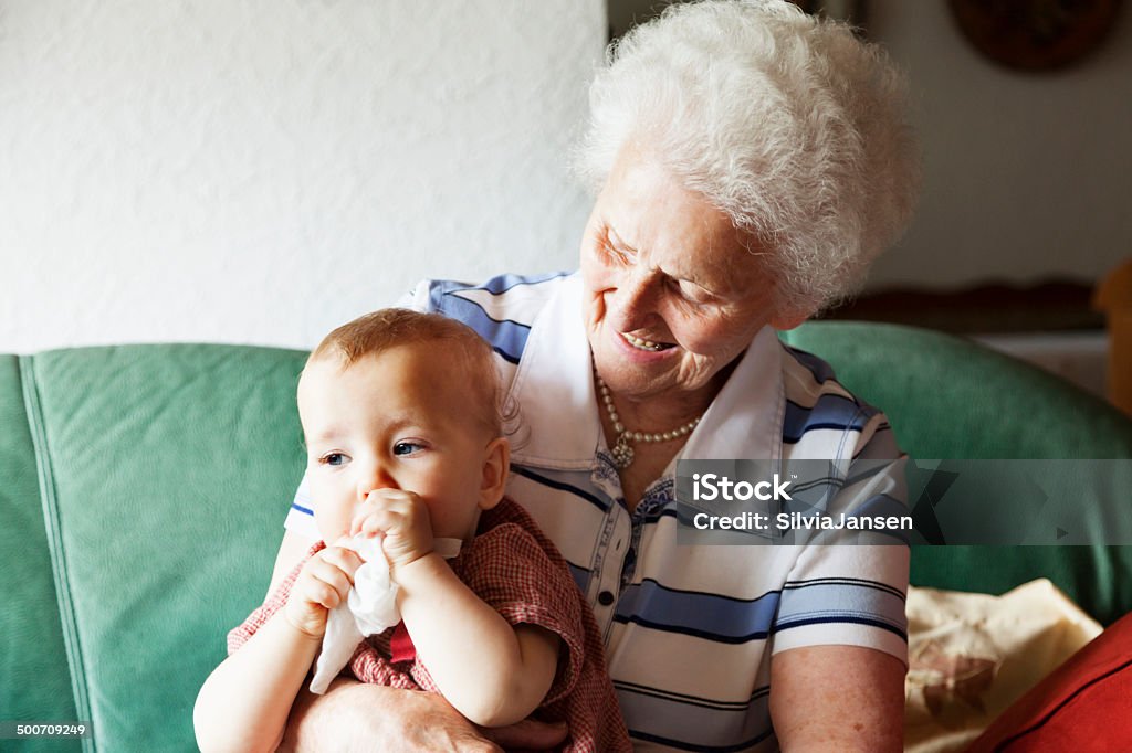 senior woman and baby girl senior woman, 88 years old, holding baby girl on her lap 6-11 Months Stock Photo