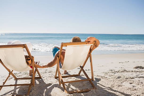 istock Cute couple lying on their deck chairs 500722159