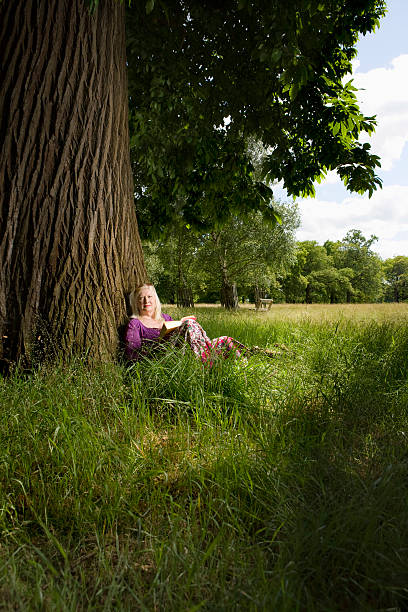 istock Woman With Book Beneath A Tree 500725045