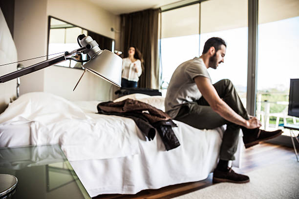 istock Couple in hotel room getting dressed 500725320