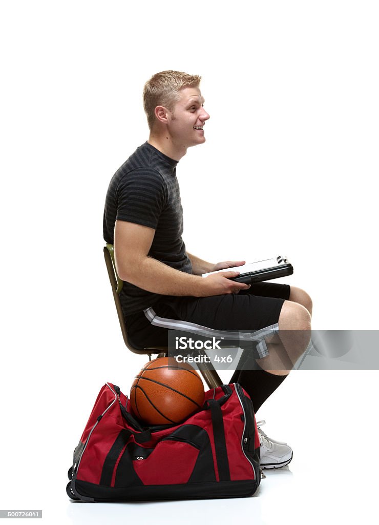 Side view of young college student sitting Side view of young college student sittinghttp://www.twodozendesign.info/i/1.png Carrying Stock Photo