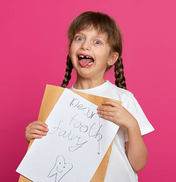 istock lost tooth girl portrait, studio shoot on pink background 500726606