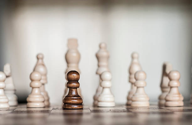 istock Lone Black Pawn Amongst Many White Pieces 500727172