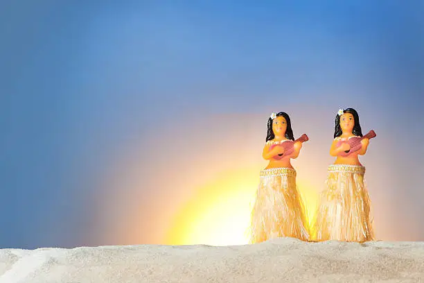 Subject: A group of hula dancer figurines on the Beach of Hawaii.