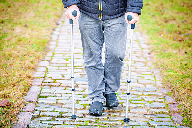 istock Disabled  veteran on crutches at cemetery 500729960
