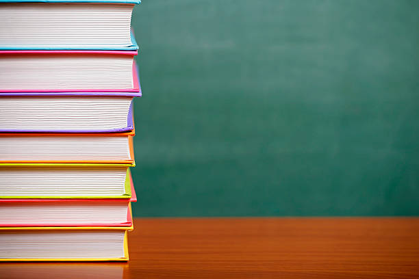 istock Stack of books on a green chalkboard background 500731368
