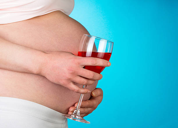 donna incinta con vino rosso - abdomen addiction adult alcohol foto e immagini stock