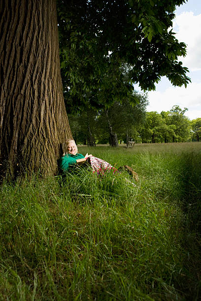 istock Woman With Book Sitting Beneath Tree 500733567