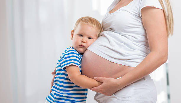 istock Kid boy hugging pregnant mother's belly 500733944