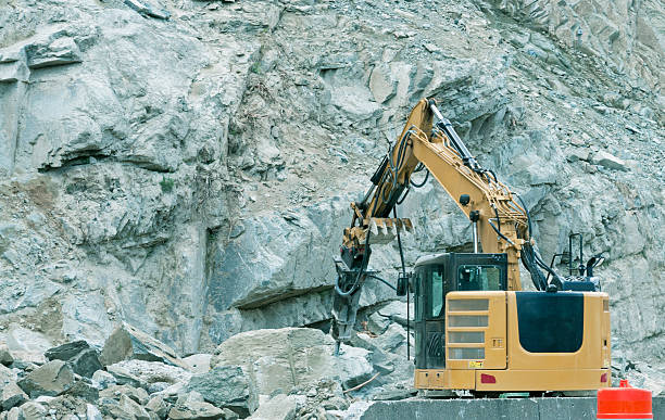 istock Crane breaking boulder in blast area on mountain pass 500734605