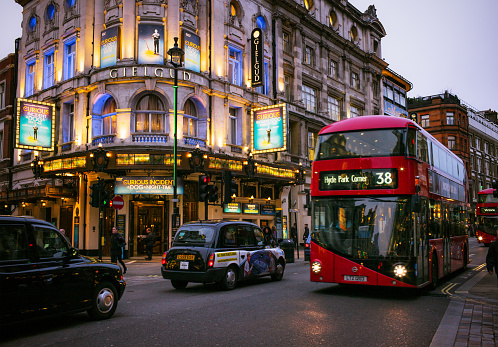 London, UK - November 23, 2015: Pedestrians, buses and taxis passing the Gielgud Theatre on Shaftesbury Avenue in London's West End, an area well known for theatre productions.