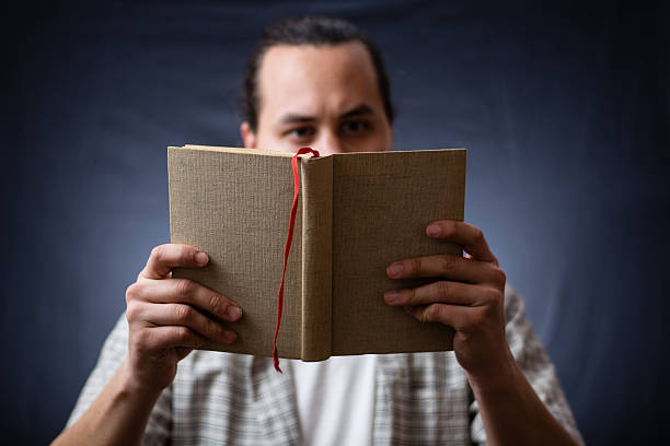 istock young man reading a book in the dark 500735138